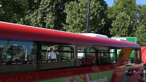 London, UK - June 22, 2018: Slow motion point of view driving on Park lane by Hyde park on sunny summer in United Kingdom UK with Big Bus guided tour, people walking on sidewalk