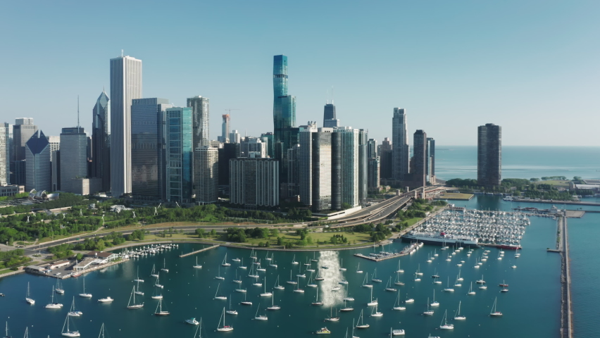 Waterfront buildings with scenic Michigan lake view. Beautiful aerial Chicago harbor and yacht club, USA water travel business footage. Blue lake with cinematic Chicago downtown cityscape background