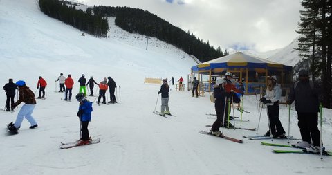 Bansko, Bulgaria - circa Jan, 2021: Skier Ski Down Slope of Mountain with Head Mounted Point of View Camera. Skiing with Snowy Trees on the Side, cinematic steadicam shot