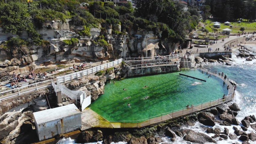 Aerial drone shot. People swimming at Bronte Baths. Waves crashing. Beautiful day. Bronte Beach, Eastern Suburbs, NSW