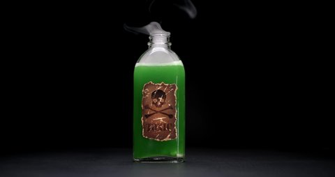 Bottle with skull and crossbones warning label, filled with toxic green liquid bubbling up and smoking. Concept for suicide by poison, murder, or poisonous substances.