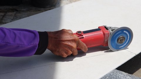 Cutting gypsum board cover by the red grinder.