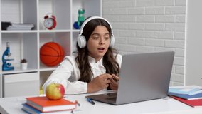 smiling student girl in headphones study at school online lesson with laptop, communication