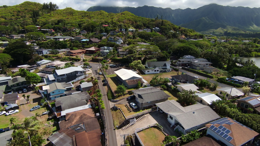 Drone Flying Over Beautiful Kaneohe neighborhood on Oahu in Hawaii, with Mountain Range in the Distance Royalty-Free Stock Footage #1079633060