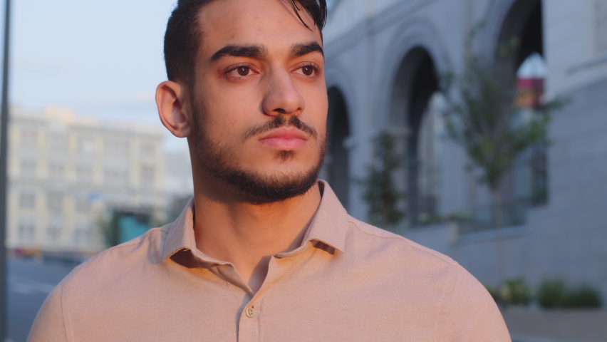 Extreme close-up male serious sad face attractive young successful pensive bearded arab business man guy hispanic boss leader standing in city on street outdoors looking in distance thinking dreaming Royalty-Free Stock Footage #1079636522