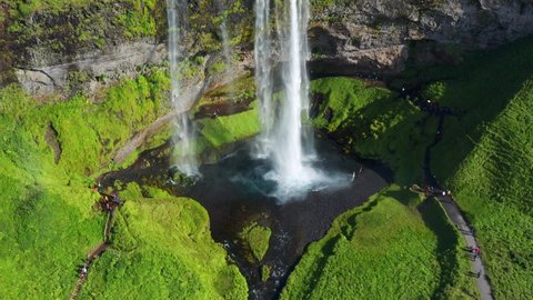 Glacier Meltwater Flowing In Seljalandsfoss Cascade Into Seljalands River with Green Nature IN South Iceland. - aerial