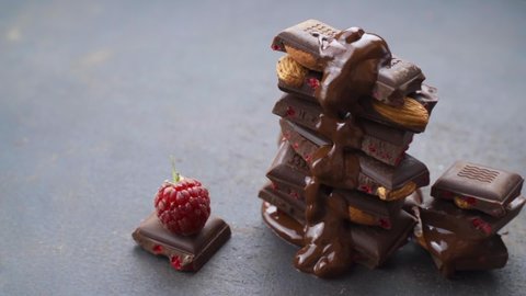 Chocolatier cover melted chocolate tower pieces chocolates. recipe For making chocolate with nuts, almonds, raspberries. Cooking handmade chocolate bar, dessert, candies. Confectionery nuts, berry 
