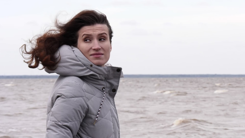 A Woman Looks at the Foamy Waves. Windy Autumn Day at the Shore of Lake Ilmen.