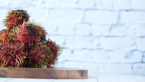 stack of rambutan in a chopping board on table 