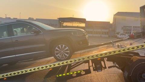 A tow truck (car transporter, lorry) dropping a car for repairing in an industrial area at sunrise
- Abu Dhabi, UAE Septemper 14, 2021