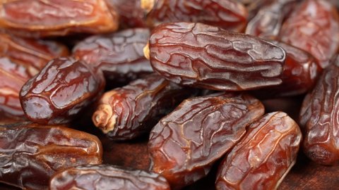 Close-up view 4K stock video footage of tasty brown dried dates fruit isolated on brown background