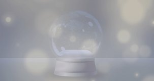 Animation of lights spots falling over snow globe on grey background. christmas, tradition and celebration concept digitally generated video.