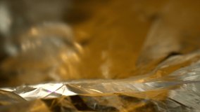 RACK FOCUSING two layers of foil with the top layer dominant. DEFOCUSED textured colorful foil with yellow and gold coloring reflect in the top layer of the foil with many contours and texturing. - Powered by Shutterstock - Get 15% off with code: PIKWIZARD15