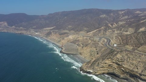 Aerial shot of the Guadalupe valley, with the federal highway 1 with trucks and the ocean in Baja California, Mexico.