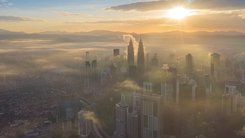 Cityscape Time lapse : Aerial Kuala Lumpur city view during morning overlooking the city skyline with beautiful ray of lights and long shadow in Malaysia. Prores Full HD