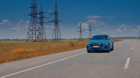 KYIV, UKRAINE - May 2021: Front view of a luxury car moving on the road in daylight. New electric car audi e-tron driving on the highway.