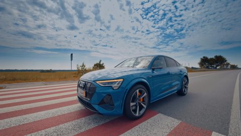 KYIV, UKRAINE - May 2021: Electric metallic blue Audi e-tron 55 quattro SUV. Audi e tron, a fully electric car on highway