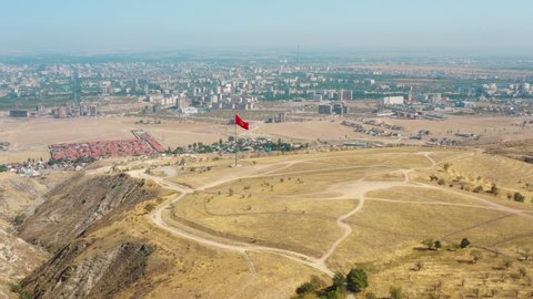 Aerial view of Bishkek city from mountains. Flagpole with Kyrgyzstan flag