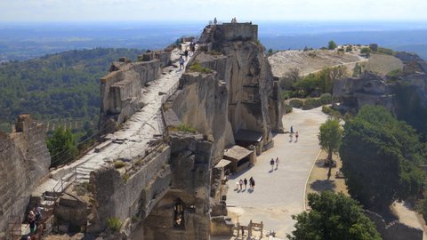Les Baux-de-Provence, France - August 2021 : Ruined castle of les Baux de Provence village with some tourists visiting