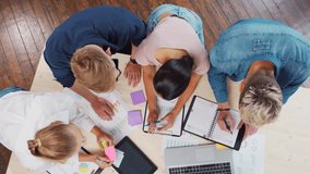 Team of young startupers is working at the table in the office, discussing the strategy and development plan of the company. Business, innovation, brainstorming and teamwork concept. - Powered by Shutterstock - Get 15% off with code: PIKWIZARD15