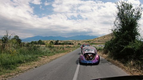 Kocani, Macedonia - 24 Jun, 2021: Classic custom VW Beetle driving on two lane road. Cars participating in VW Ranch Run