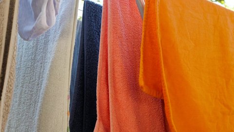 Wind slowly moves the colorful drying towels on the patio.