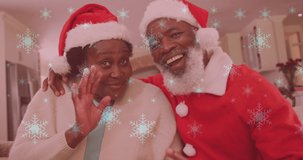 Animation of snow falling over smiling couple wearing santa hats and waving hands. christmas, winter, tradition and celebration concept digitally generated video.