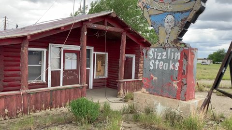 Powder River, Wyoming - June 26, 2021: Abandoned Tumble Inn lounge, cafe and steakhouse has been closed since 2005. Famous, iconic neon sign with a cowboy