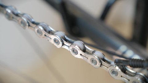 Close up of bicycle chain. Bike maintenance. Bicycle mechanic lubricating bike chain with special white lube. Bike service. Bicycle workshop