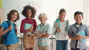 Portrait of cheerful smiling diverse multiethnic elementary school children standing posing in classroom looking at camera happy after school reopen. Diversity. Back to school concept. - Powered by Shutterstock - Get 15% off with code: PIKWIZARD15