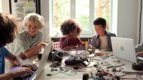 Group of multieracial schoolchildren interacting using gadgets laptops for programming at robotics engineering class. School science classroom of futuristic technologies. STEM education concept. - Powered by Shutterstock - Get 15% off with code: PIKWIZARD15