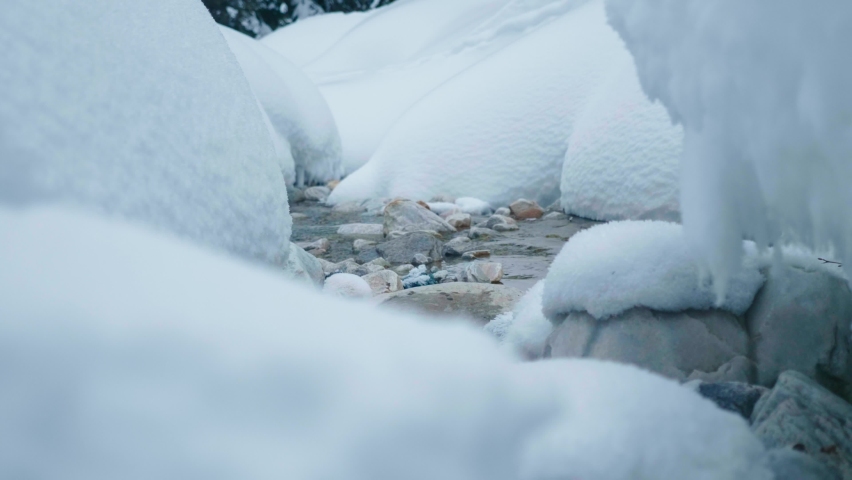 Fresh powder snow stacked on rocks of small tranquil creek, winter season Royalty-Free Stock Footage #1079707235
