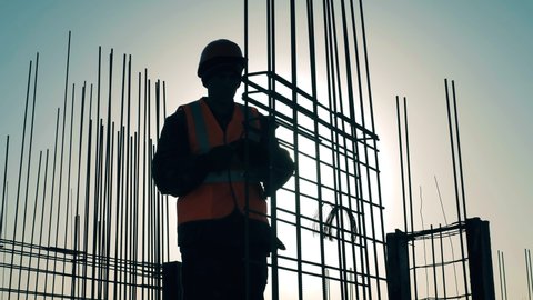 One man works with reinforcement bars on construction site.
