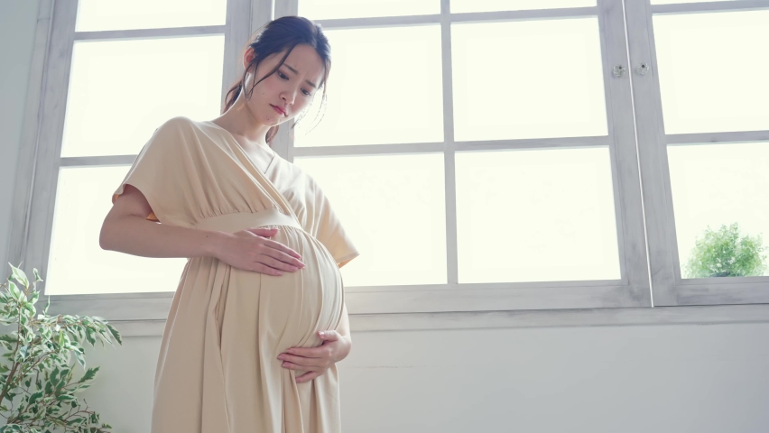 Thinking pregnant Asian woman concept. Maternity melancholy. Royalty-Free Stock Footage #1079714945