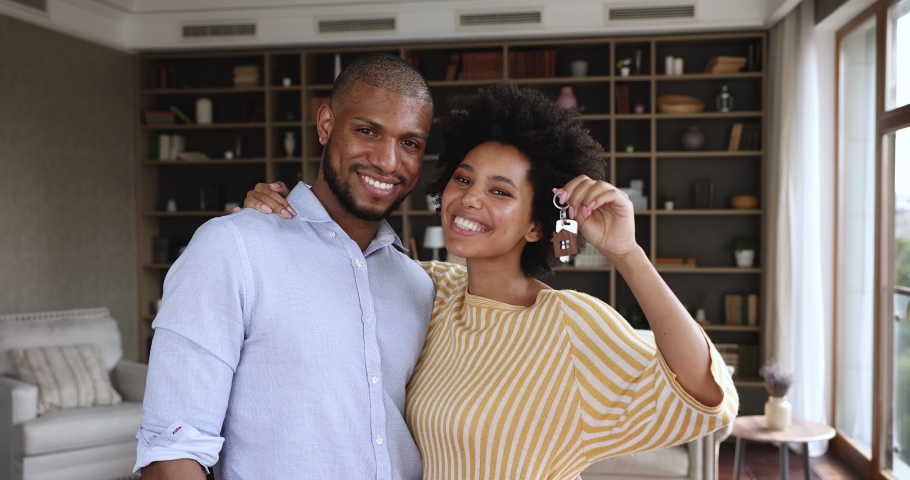 Happy homeowners African couple showing keys from their new house, first real-estate property, smile look at camera enjoy relocation day, new life starts. Bank loan, mortgage for young family concept Royalty-Free Stock Footage #1079720261