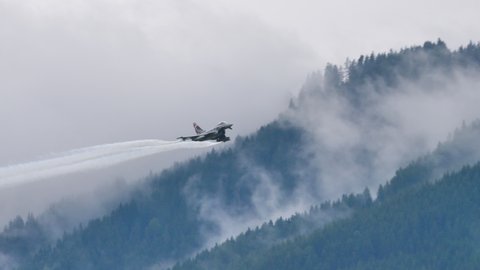 Zeltweg Austria SEPTEMBER, 6, 2019 Military fighter jet plane simulates combat maneuvers in the grey cloudy sky. Eurofighter Typhoon EFA of Austrian Air Force