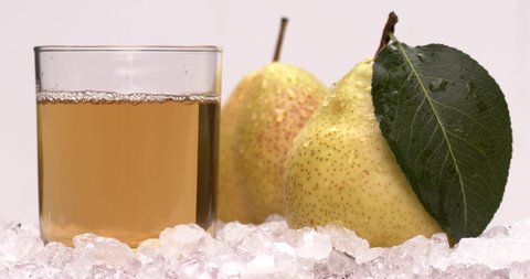 Yellow pear juice in cold ice with fresh and yummy pears, natural and organic fruits in black background. Filmed high speed cinema camera, slow motion footage, 8K downscale, 4K.