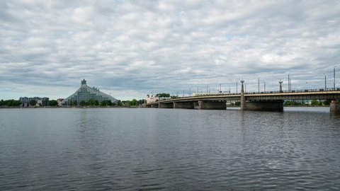Riga, Latvia. August 2021. Time lapse view of Daugava river with the National Library of Latvia building on the background.