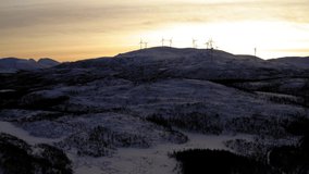 Video of calm tranquil environment on north with tall steel wind turbines spinning and generating electricity, farm of renewable and alternative power during winter season