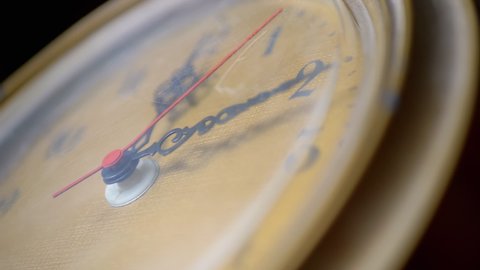 Vintage retro watch with a yellow scratched dial. Twelve o'clock. Noon. Movement of red second hand on an old quartz watch. Antique collectors item. Time concept. Zoom. Close-up. Slow-motion