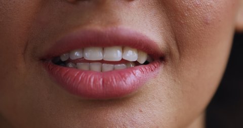 Close up shot of young biracial female mouth moving lips talking speaking making speech. Lower part face detail of millennial woman speaker with beautiful teeth holding conversation giving monologue