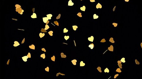 Falling gold hearts on a black background. 3D rendering of animation. Video effect for valentine's day and weddings.  Rain from hearts.
