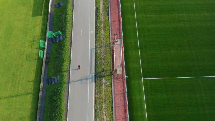 Active man in line skating on the track near the stadium 
