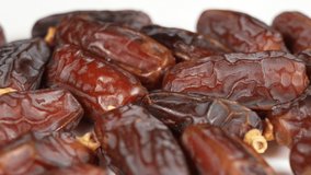 Close-up view 4K stock video footage of tasty brown dried dates fruit isolated on white background