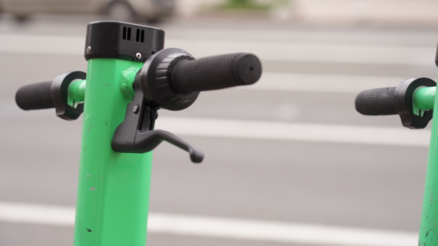 Electric scooter rental on the city street. Close-up. Electric scooters are parked in a row on the sidewalk 