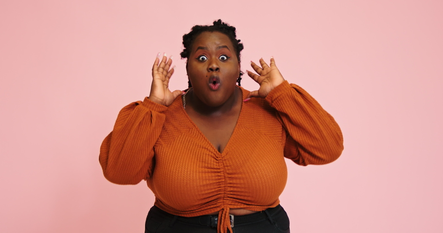 Plump black woman says Wow demonstrating surprised face expression and covers mouth with hands looking into camera slow motion | Shutterstock HD Video #1079740157