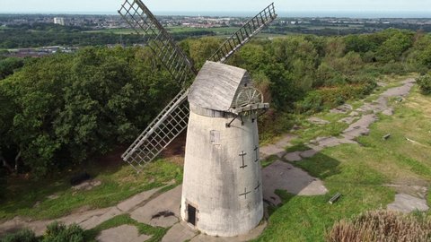 Bidston hill disused rural flour mill restored traditional wooden sail windmill Birkenhead aerial view close orbit left