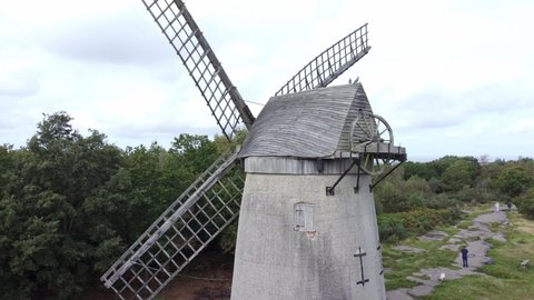 Bidston hill disused rural flour mill restored traditional wooden sail windmill Birkenhead aerial view closeup orbiting right