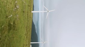 Wind turbine driven by wind in a stormy natural environment. Vertical footage