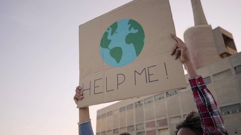 Help me poster claim during a street protestor for climate change. Slow motion.